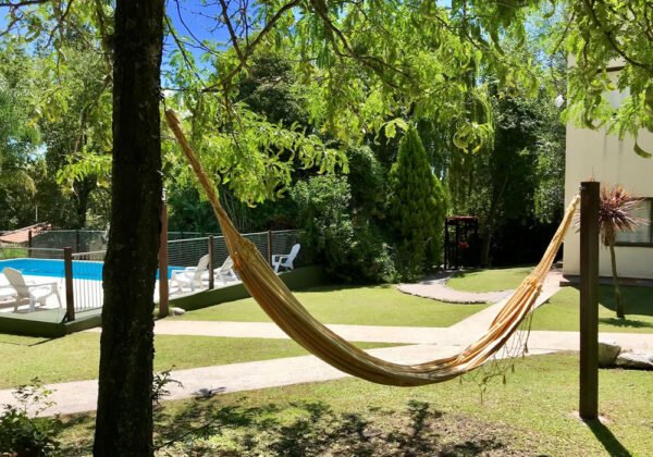 exterior cabañas con vegetación y una hamaca